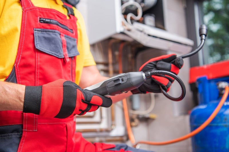 A plumber using a device to detect leakage
