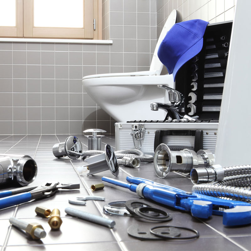 toilet and tools on the floor of a bathroom
