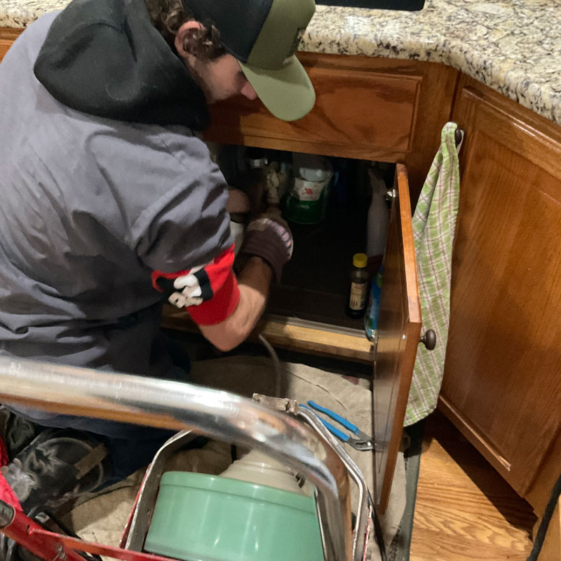 plumber cleaning a kitchen drain